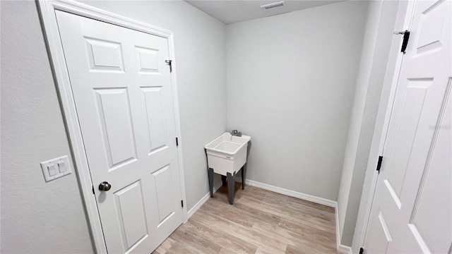 4413 Grass Ave, Sebring, FL 33875 - laundry area featuring light wood-style flooring and baseboards