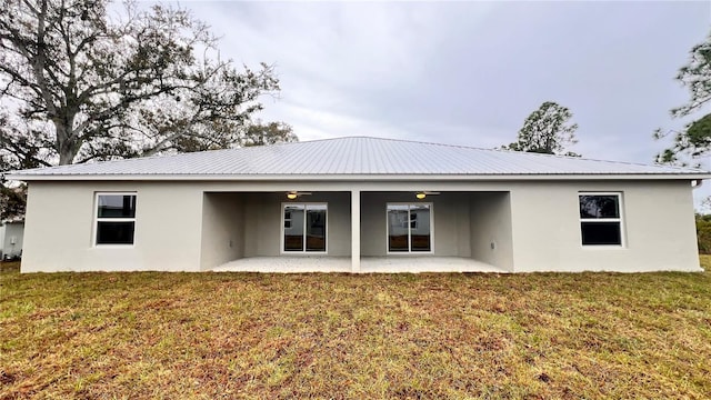 4413 Grass Ave, Sebring, FL 33875 - back of property featuring stucco siding, a yard, a patio, and a metal roof