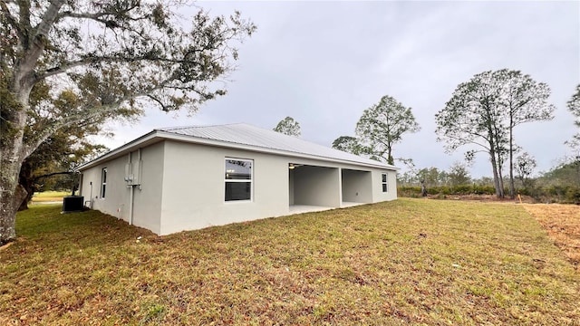 4413 Grass Ave, Sebring, FL 33875 - back of house with stucco siding, a yard, and a metal roof