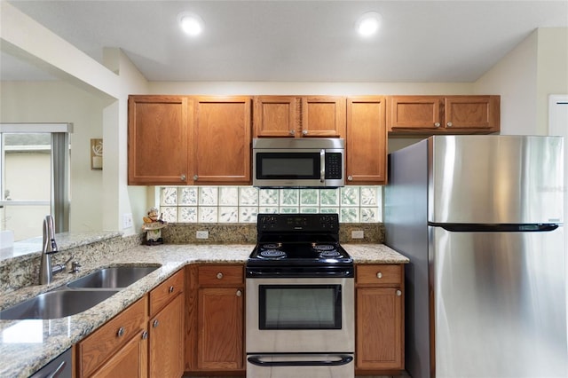 162 Canary Island Cir, Davenport, FL 33837 - kitchen with stainless steel appliances, backsplash, brown cabinets, and light stone countertops