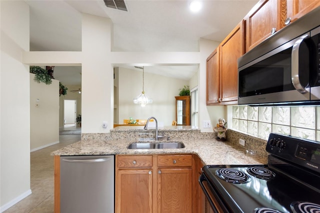 162 Canary Island Cir, Davenport, FL 33837 - kitchen featuring appliances with stainless steel finishes, light stone countertops, lofted ceiling, decorative light fixtures, and light tile patterned flooring