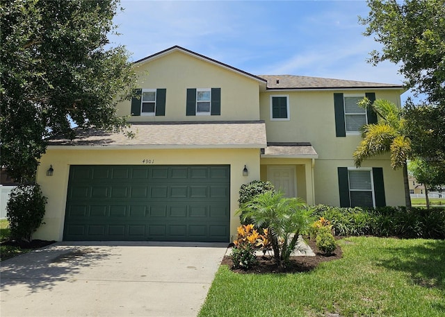 4901 Stone Acres Cir, Saint Cloud, FL 34771 - townhome / multi-family property featuring stucco siding, a garage, driveway, roof with shingles, and a front lawn