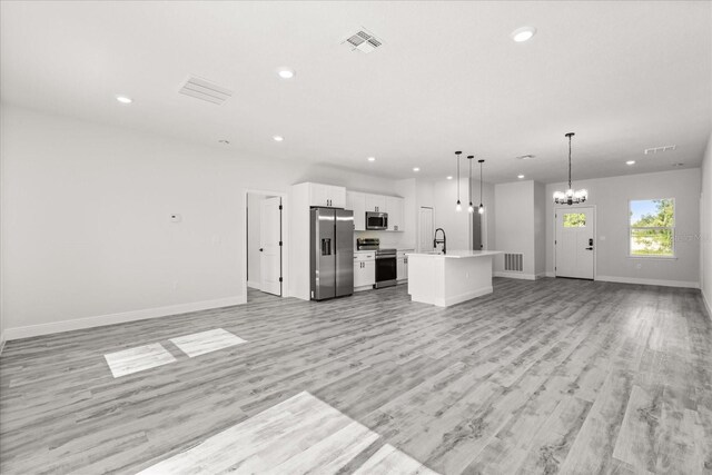 16057 SW 17th Ave, Ocala, FL 34473 - unfurnished living room with a chandelier, recessed lighting, and light wood-style floors