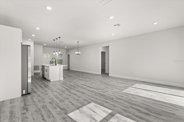 16057 SW 17th Ave, Ocala, FL 34473 - unfurnished living room with recessed lighting, light wood-type flooring, and a chandelier
