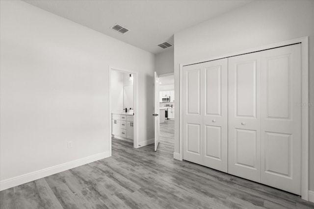 16057 SW 17th Ave, Ocala, FL 34473 - unfurnished bedroom with wood finished floors, a closet, and ensuite bathroom