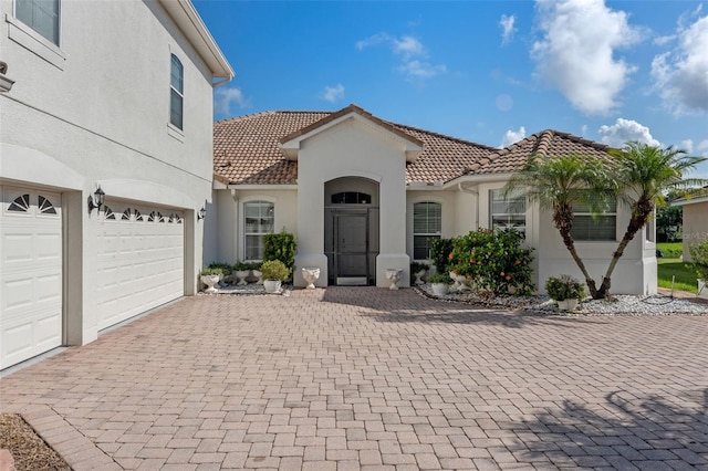 3774 Eagle Isle Cir, Kissimmee, FL 34746 - mediterranean / spanish home with a tiled roof, decorative driveway, stucco siding, and a garage