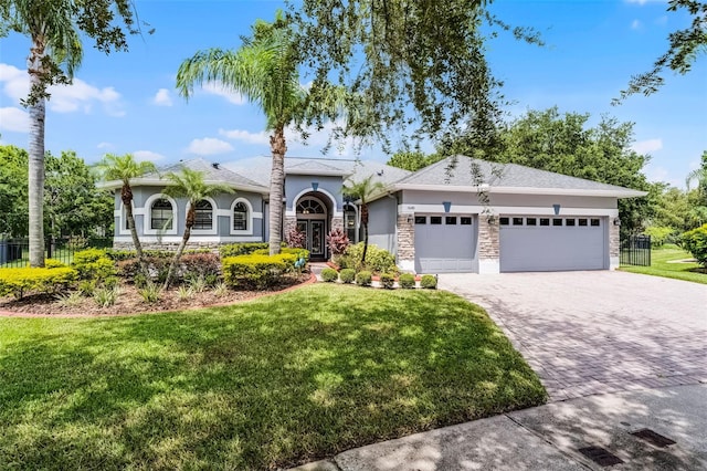 1640 Wild Indigo Ter, Oviedo, FL 32766 - view of front facade featuring stucco siding, a garage, decorative driveway, and stone siding