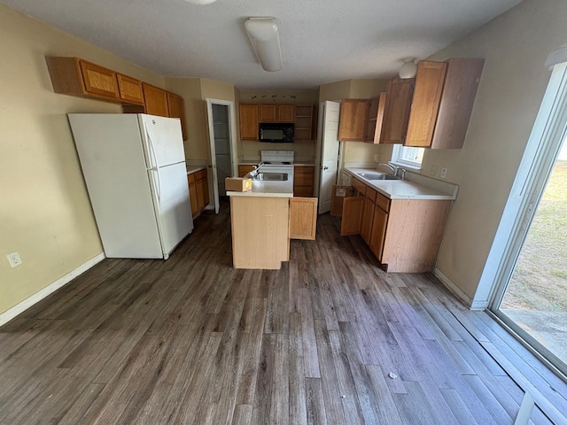 266 Vervain Ave, Davenport, FL 33837 - kitchen with white appliances, a center island with sink, dark wood finished floors, and healthy amount of natural light