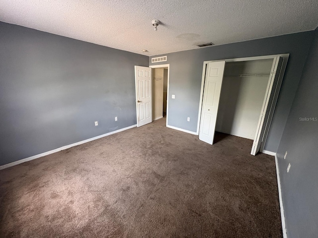 266 Vervain Ave, Davenport, FL 33837 - unfurnished bedroom with dark carpet, a textured ceiling, and a closet