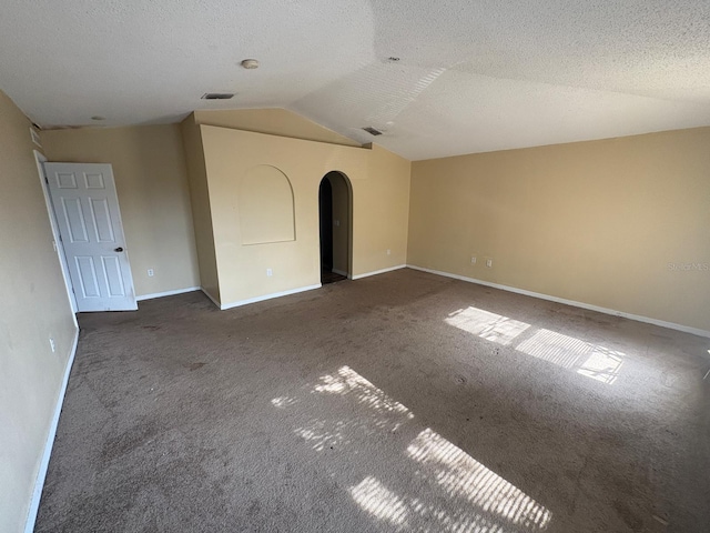 266 Vervain Ave, Davenport, FL 33837 - empty room featuring carpet floors, vaulted ceiling, arched walkways, and a textured ceiling