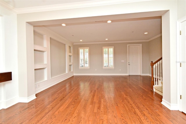 1649 Lake Baldwin Ln, Orlando, FL 32814 - spare room featuring wood finished floors, stairway, crown molding, built in shelves, and recessed lighting