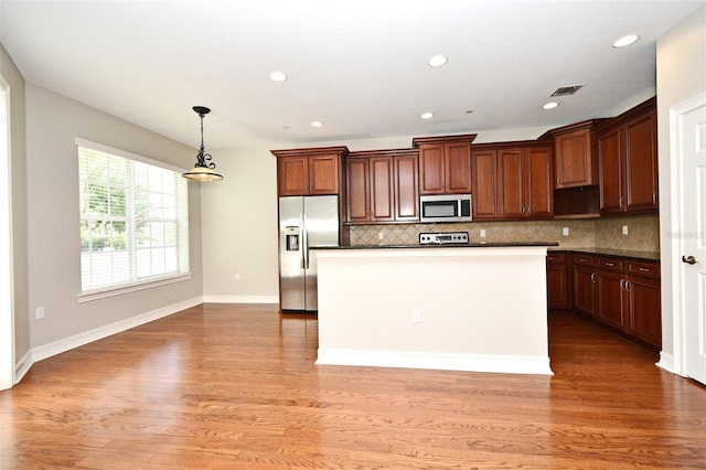 1649 Lake Baldwin Ln, Orlando, FL 32814 - kitchen with stainless steel appliances, dark countertops, decorative backsplash, light wood-style floors, and recessed lighting