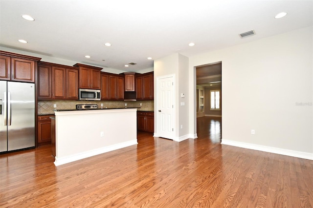 1649 Lake Baldwin Ln, Orlando, FL 32814 - kitchen featuring stainless steel appliances, recessed lighting, light wood-style flooring, decorative backsplash, and a kitchen island