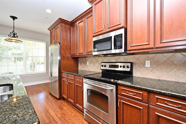1649 Lake Baldwin Ln, Orlando, FL 32814 - kitchen with stainless steel appliances, wood finished floors, pendant lighting, decorative backsplash, and recessed lighting
