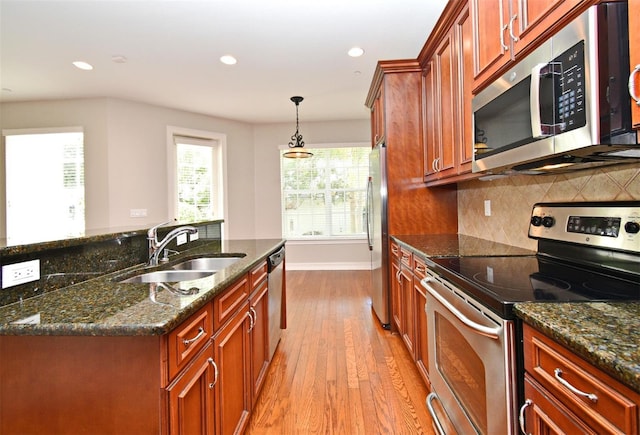 1649 Lake Baldwin Ln, Orlando, FL 32814 - kitchen with stainless steel appliances, wood finished floors, recessed lighting, backsplash, and dark stone countertops