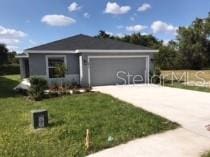 4844 Summerfield Cir, Winter Haven, FL 33881 - ranch-style home with an attached garage, driveway, and a front yard