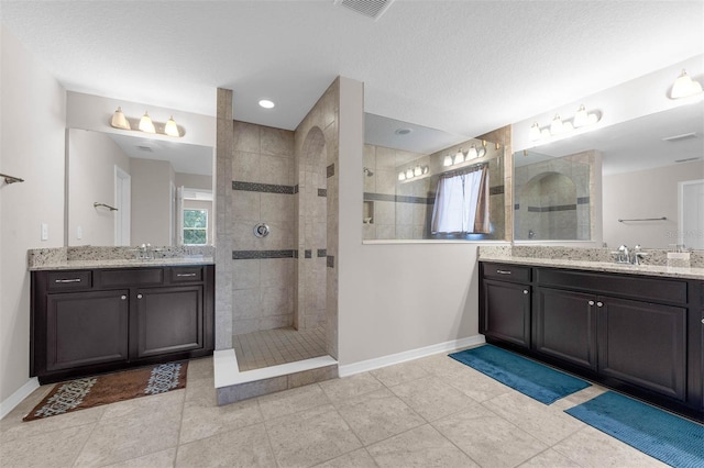 1270 Fountain Coin Loop, Orlando, FL 32828 - full bathroom with walk in shower, two vanities, a textured ceiling, and tile patterned flooring