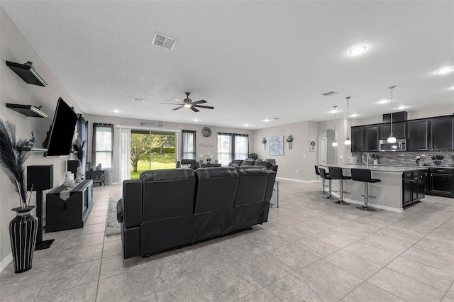 1270 Fountain Coin Loop, Orlando, FL 32828 - living area with ceiling fan, recessed lighting, arched walkways, and light tile patterned floors
