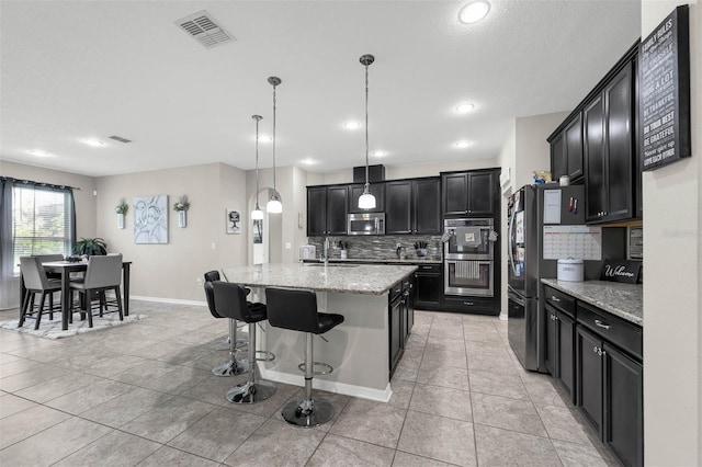1270 Fountain Coin Loop, Orlando, FL 32828 - kitchen featuring appliances with stainless steel finishes, dark cabinetry, decorative backsplash, light tile patterned floors, and recessed lighting
