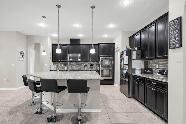 1270 Fountain Coin Loop, Orlando, FL 32828 - kitchen with appliances with stainless steel finishes, arched walkways, dark cabinetry, tasteful backsplash, and recessed lighting