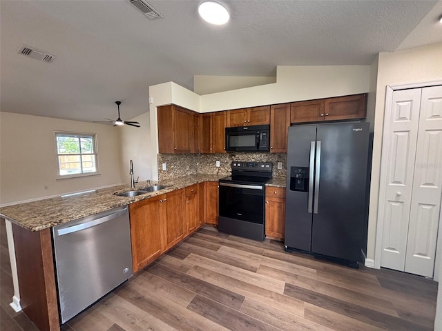 3055 Kirkland St, Deltona, FL 32738 - kitchen with black appliances, wood finished floors, stone countertops, vaulted ceiling, and ceiling fan