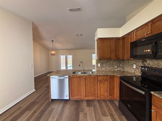 3055 Kirkland St, Deltona, FL 32738 - kitchen featuring black appliances, a peninsula, brown cabinetry, dark wood-type flooring, and vaulted ceiling