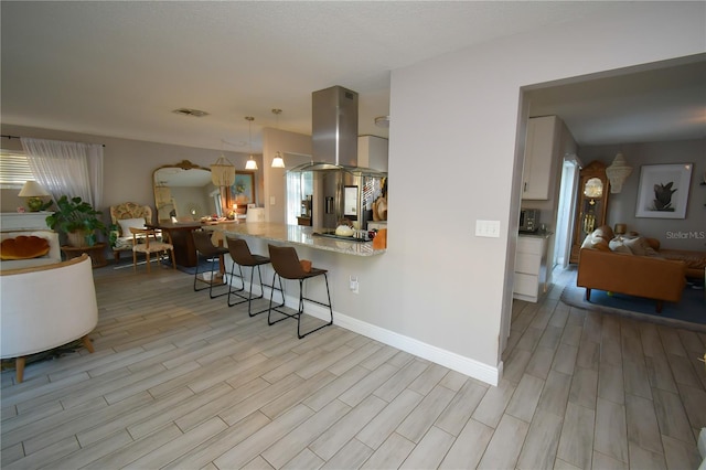 628 Riverview Ave, Altamonte Springs, FL 32714 - kitchen featuring open floor plan, island range hood, a breakfast bar area, and light wood-style floors