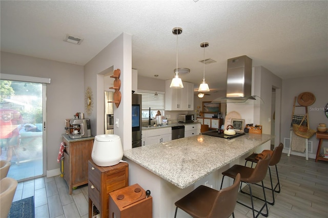 628 Riverview Ave, Altamonte Springs, FL 32714 - kitchen featuring island exhaust hood, stainless steel appliances, white cabinets, a breakfast bar, and a peninsula
