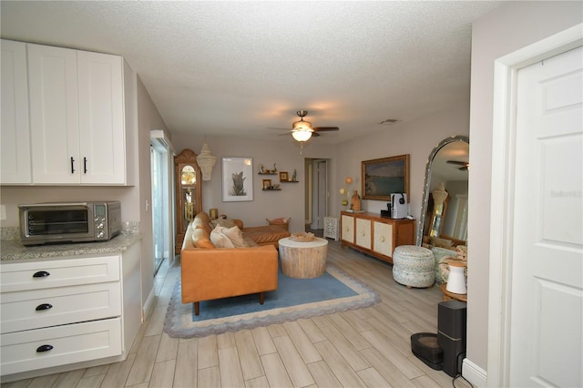628 Riverview Ave, Altamonte Springs, FL 32714 - living area with a ceiling fan, light wood-style flooring, and a textured ceiling