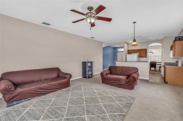 209 Grouper Ct, Poinciana, FL 34759 - living area with arched walkways, ceiling fan, and light carpet