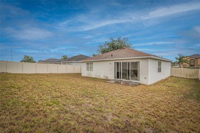 209 Grouper Ct, Poinciana, FL 34759 - back of property featuring stucco siding, a fenced backyard, and roof with shingles