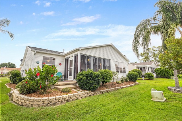 8076 SE 174th Belhaven Loop, The Villages, FL 32162 - rear view of property featuring a lawn and a sunroom