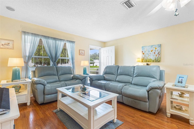 8076 SE 174th Belhaven Loop, The Villages, FL 32162 - living room featuring a textured ceiling, wood finished floors, and ceiling fan