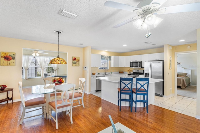 8076 SE 174th Belhaven Loop, The Villages, FL 32162 - dining area featuring ceiling fan, a textured ceiling, and light wood-type flooring