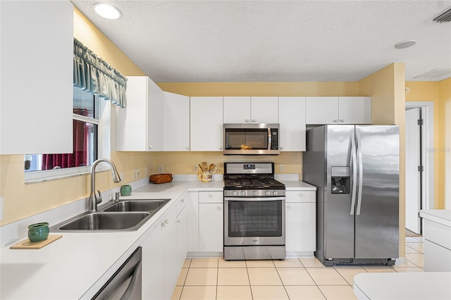 8076 SE 174th Belhaven Loop, The Villages, FL 32162 - kitchen with stainless steel appliances, light countertops, white cabinetry, a textured ceiling, and light tile patterned floors