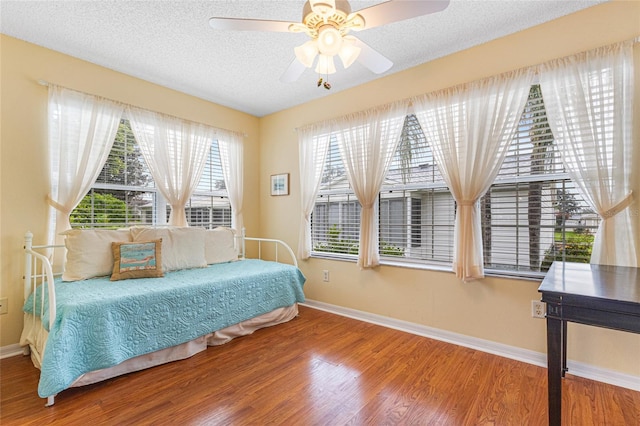 8076 SE 174th Belhaven Loop, The Villages, FL 32162 - bedroom featuring wood finished floors, a textured ceiling, and ceiling fan