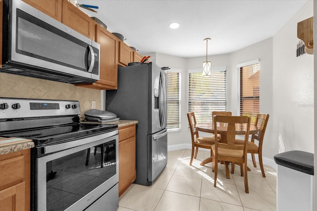 7421 Sugar Bend Dr Unit 7421, Orlando, FL 32819 - kitchen with stainless steel appliances, tasteful backsplash, recessed lighting, brown cabinetry, and decorative light fixtures