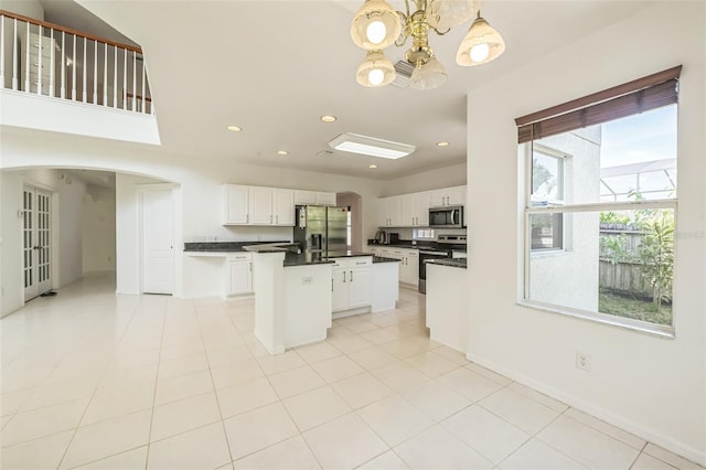 7716 Nottinghill Sky Dr, Apollo Beach, FL 33572 - kitchen featuring appliances with stainless steel finishes, dark countertops, arched walkways, a chandelier, and recessed lighting