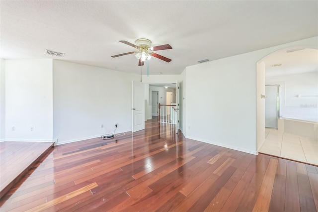 7716 Nottinghill Sky Dr, Apollo Beach, FL 33572 - unfurnished room with arched walkways, hardwood / wood-style floors, and a ceiling fan