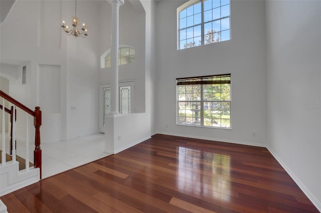 7716 Nottinghill Sky Dr, Apollo Beach, FL 33572 - entryway featuring a towering ceiling, stairs, hardwood / wood-style floors, a chandelier, and ornate columns