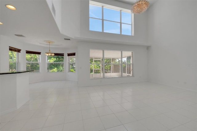 7716 Nottinghill Sky Dr, Apollo Beach, FL 33572 - spare room with a chandelier, light tile patterned floors, a towering ceiling, and recessed lighting