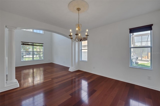 7716 Nottinghill Sky Dr, Apollo Beach, FL 33572 - empty room featuring arched walkways, plenty of natural light, a chandelier, and hardwood / wood-style floors