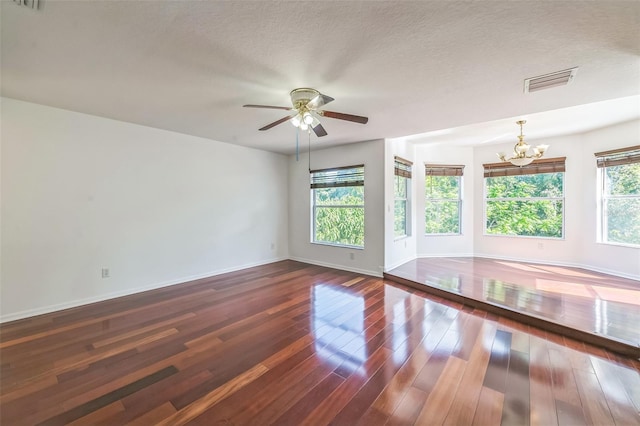 7716 Nottinghill Sky Dr, Apollo Beach, FL 33572 - unfurnished room with a chandelier, healthy amount of natural light, dark wood-style flooring, ceiling fan, and a textured ceiling
