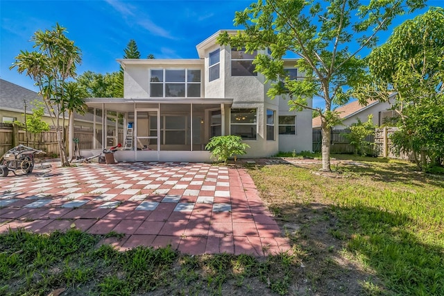 7716 Nottinghill Sky Dr, Apollo Beach, FL 33572 - rear view of house featuring a sunroom, stucco siding, a fenced backyard, and a patio