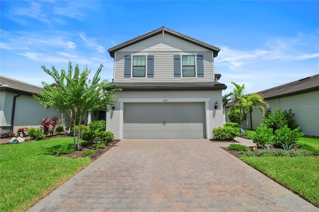 6256 Baywood Ct, Bradenton, FL 34211 - view of front of house featuring a front yard, an attached garage, decorative driveway, and stucco siding