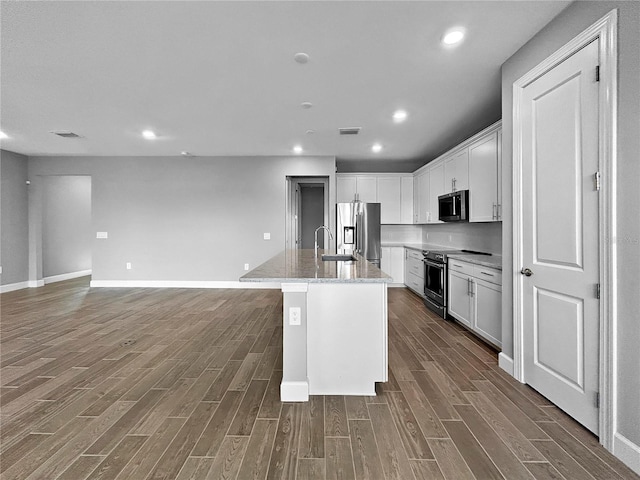 6256 Baywood Ct, Bradenton, FL 34211 - kitchen featuring stainless steel appliances, dark wood-style floors, white cabinets, a center island with sink, and recessed lighting