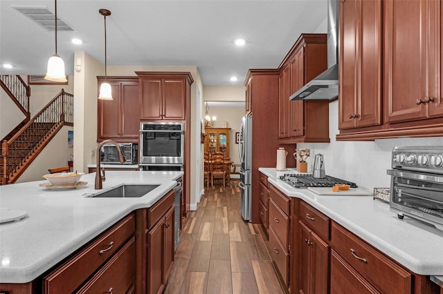 13525 Gorgona Isle Dr, Windermere, FL 34786 - kitchen with wall chimney exhaust hood, stainless steel appliances, wood finished floors, light countertops, and hanging light fixtures