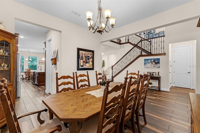 13525 Gorgona Isle Dr, Windermere, FL 34786 - dining space with a chandelier, stairs, and wood finished floors