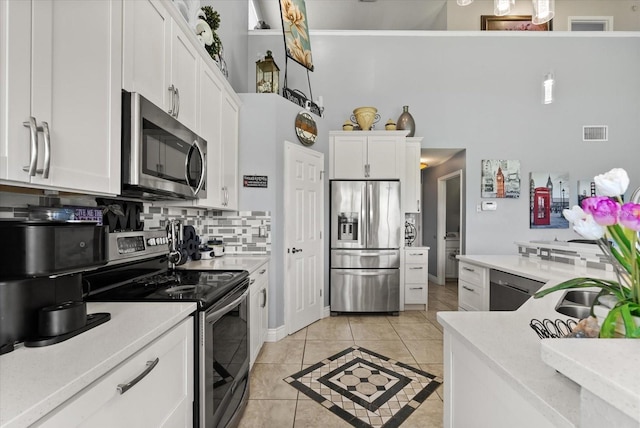 13147 Meergate Cir, Orlando, FL 32837 - kitchen featuring appliances with stainless steel finishes, white cabinetry, backsplash, and light countertops