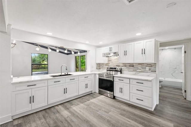 18015 Beach St, Umatilla, FL 32784 - kitchen with stainless steel electric stove, under cabinet range hood, light wood finished floors, white cabinets, and recessed lighting